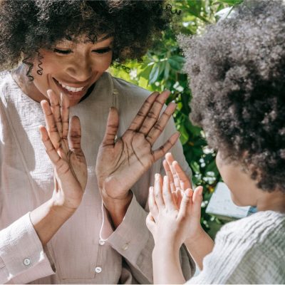 a photo of a woman playing with a child illustrates a guest post on parental well-being investment