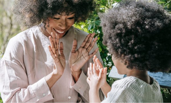 a photo of a woman playing with a child illustrates a guest post on parental well-being investment